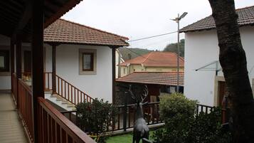Un quartier résidentiel avec un escalier, une statue de cerf et des maisons aux toits recouverts de tuiles rouges.