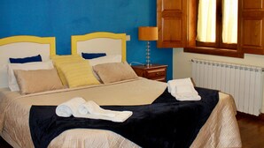 A bedroom with a bed, wooden headboard, a nightstand, a lamp, a window with curtains, and a radiator. - Double Room 4 - Solar de Rabal with Private Bathroom (Rabal)
