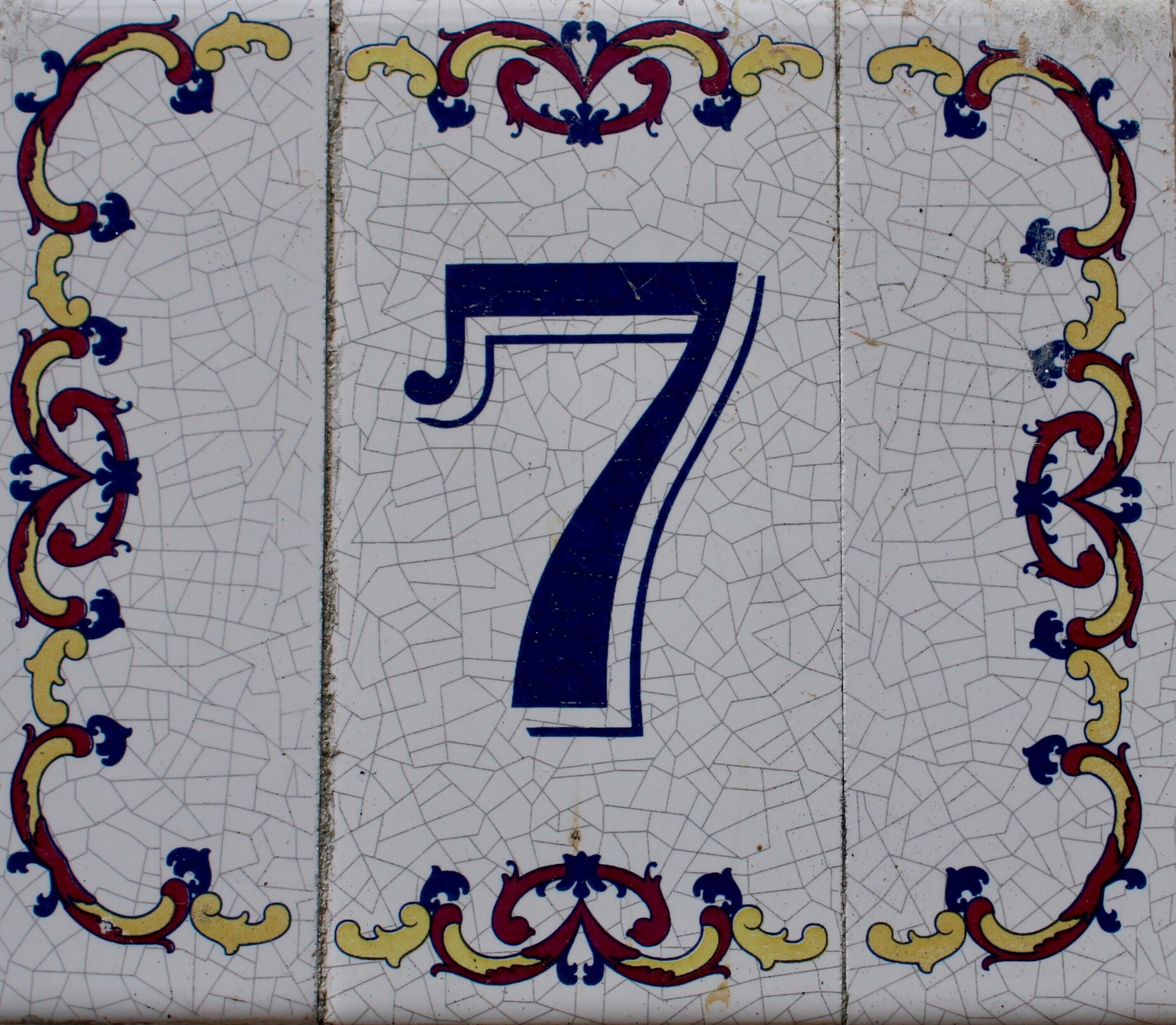 Un mosaico de azulejos con el número 7 en grande, rodeado de diseños decorativos.