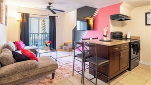Un espacio habitable compacto con kitchenette, comedor y balcón con vistas.