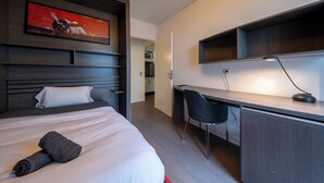 A modern hotel room with a large bed, a desk, and a chair. There is a painting on the wall and a lamp on the desk. - 9 - L'Envol - Gare - Wifi (Toulouse)