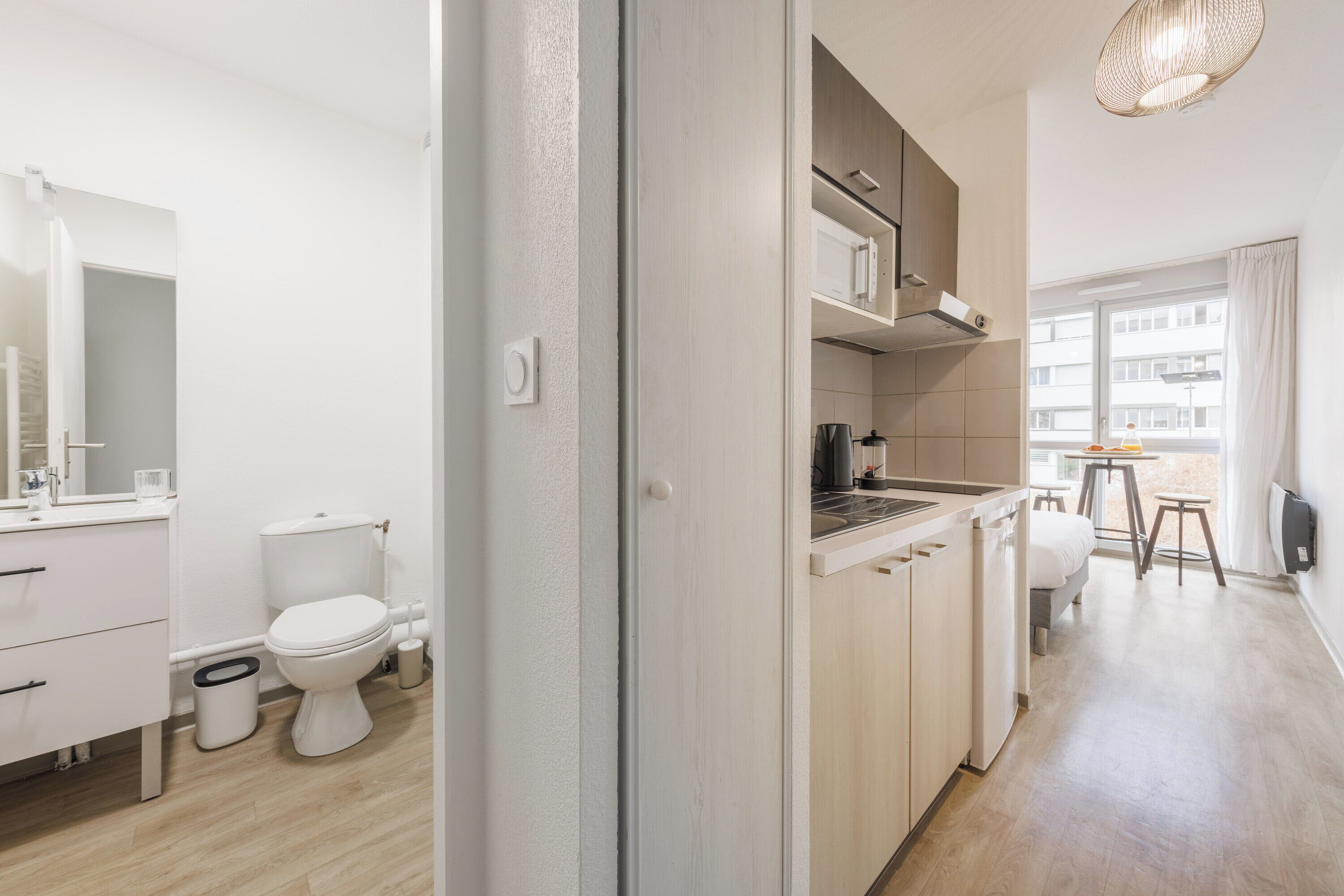 Een moderne keuken met een eethoek, een klein tafeltje en uitzicht op buiten.
