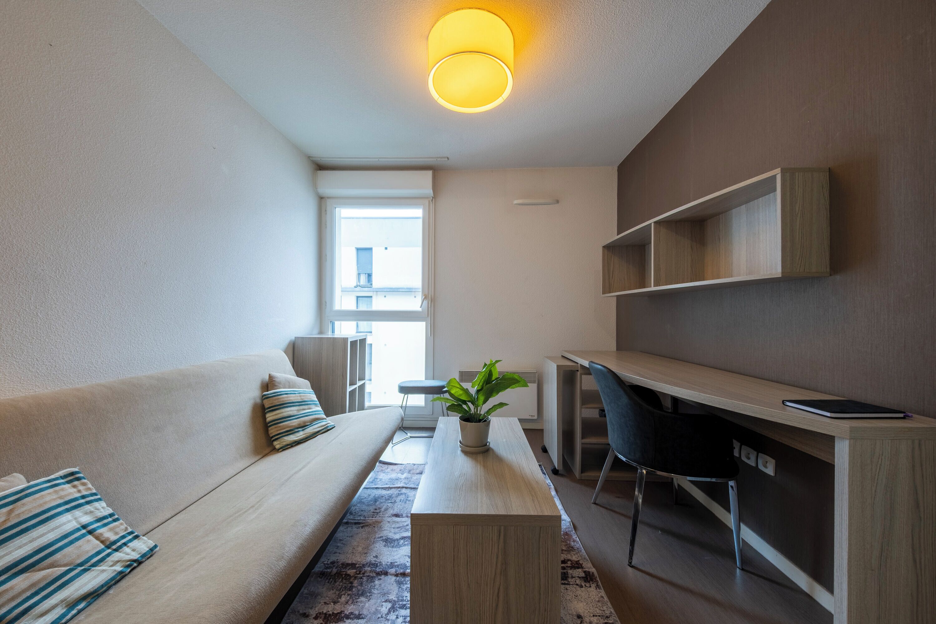 Ein modernes Wohnzimmer mit einer Couch, einem Couchtisch, einem Schreibtisch und einem Sessel.