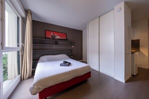 Ein modernes Schlafzimmer mit Bett, Kleiderschrank und einem fensterbepflanzten Fenster.