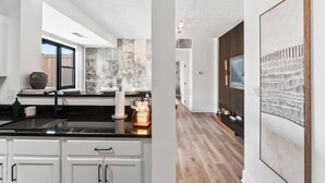 A modern kitchen with a large window, a sink, and a countertop. - Solara – Luxury 1BR Downtown (Stamford)
