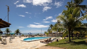 Ein Pool mit Liegestühlen und Palmen.