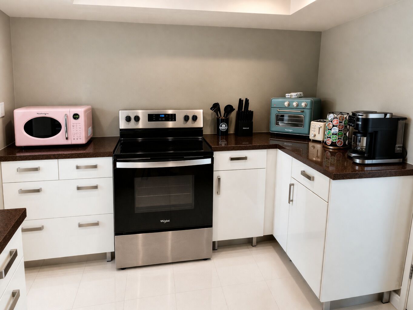 A kitchen with a stainless steel stove, a microwave, a toaster, and a coffee maker.