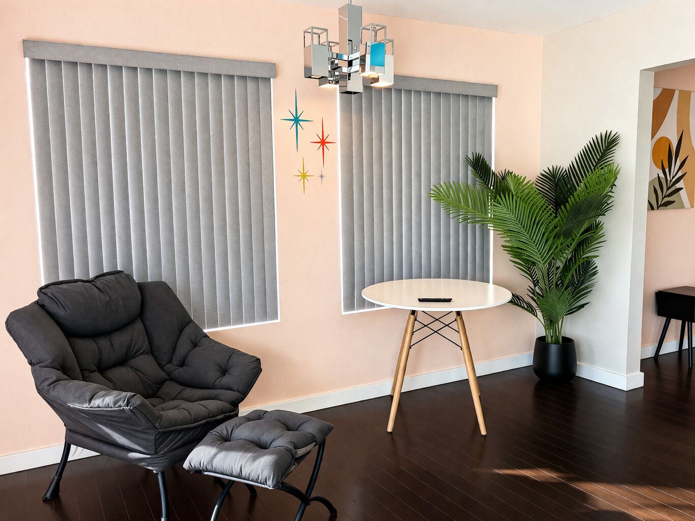 A modern living room with a tufted armchair, a round table, and a potted plant.