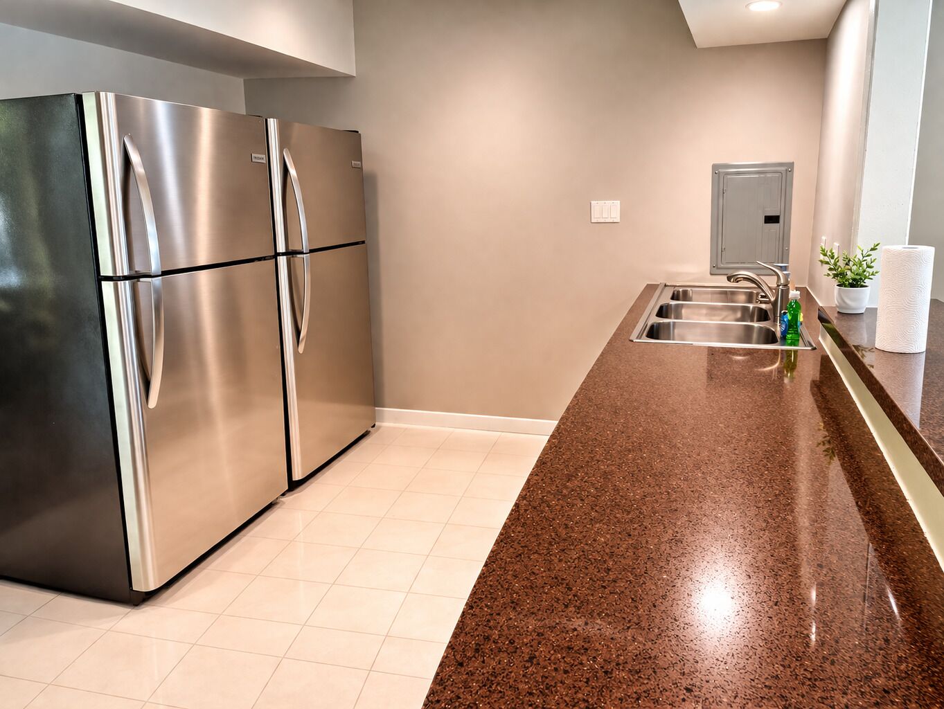 Una cocina moderna con electrodomésticos de acero inoxidable, encimera de granito y un fregadero.