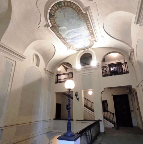 A grand interior with arched ceilings and a central staircase.