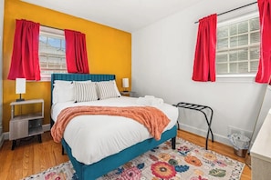A bedroom with a bed, nightstands, a lamp, a window with curtains, and a radiator. - 
Arlington Charm  Cozy 5BR Home Sleeps10  Near DC (Arlington)