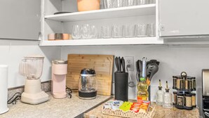 Une cuisine équipée d’un plan de travail, d’un mixeur, d’un grille-pain, d’un bloc à couteaux et d’une planche à découper.