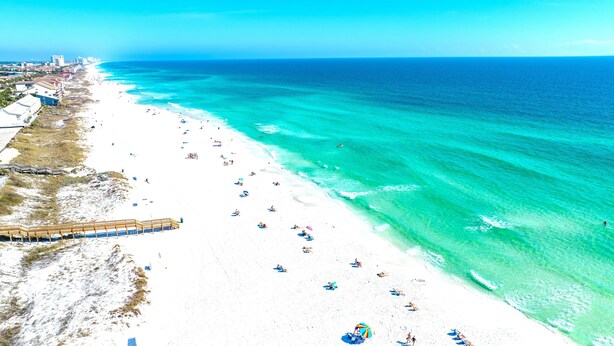 A beach with a wooden boardwalk, white sandy beach, and clear turquoise waters. - Windsong! New! Sleeps 19! Beach! (Destin)