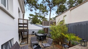 A patio with outdoor furniture, a table, and chairs. - Villa des Mahonies just 200m from the beach (La Tranche-sur-Mer)