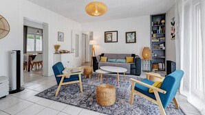 A modern living room with a sofa, two armchairs, a coffee table, a lamp, and a bookshelf. - Villa des Mahonies just 200m from the beach (La Tranche-sur-Mer)