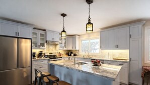 A modern kitchen with a central island, stainless steel appliances, and pendant lighting. - River Retreat- Hot tub/Games/BBQ/Bonfire/Sleeps 14 (Tweed)