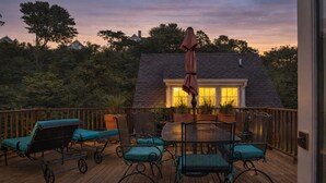 A wooden deck with outdoor furniture, a pergola, and a house in the background. - Harbor Views, Parking, Roof Deck, Beach - West End (Provincetown)