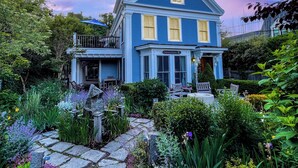 A two-story house with a balcony and a garden in front. - Harbor Views, Parking, Roof Deck, Beach - West End (Provincetown)