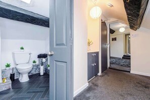 A modern bathroom with a toilet, sink, and cabinet. - Charming Grade II Listed Apartment | Sleeps 4 (Wem)