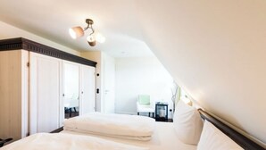 A bedroom with a bed, a wardrobe, and a nightstand.