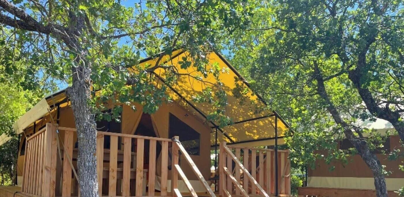 Eine hölzerne Struktur mit Balkon, umgeben von Bäumen.