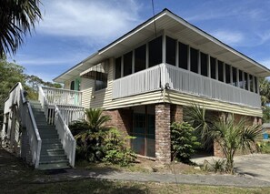 A two-story building with a balcony, a staircase, and a brick foundation. - Red Fish - close to beach, lots of amenities (Tybee Island)