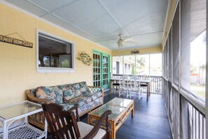 A covered porch with a sofa, chairs, and a table, a ceiling fan, and a sign reading 'Beach Bum Club'. - Red Fish - close to beach, lots of amenities (Tybee Island)