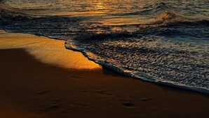 A sunset over a beach with waves gently lapping at the shore. - Chalet near the beach, with kitchen and balcony with hammock. Couples and families with children (São Miguel do Gostoso)