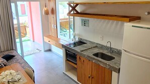 A modern kitchen with wooden cabinets, a marble countertop, and a built-in sink. - Chalet near the beach, with kitchen and balcony with hammock. Couples and families with children (São Miguel do Gostoso)