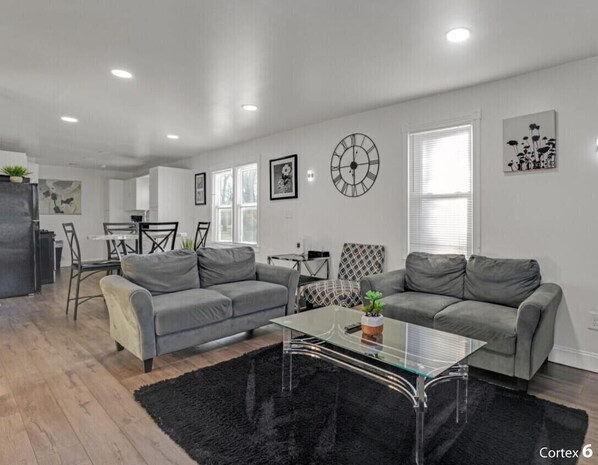 A modern living room with two grey sofas, a glass coffee table, and a black rug. - Private 4 BDRM house, 5 Miles from Downtown #1 (Indianapolis)