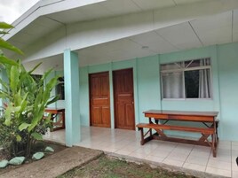 A building with a covered porch, a wooden bench, and a door.