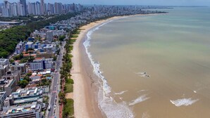 An aerial view of a coastal city with a wide beach, high-rise buildings, and a clear view of the ocean. - Unity Cabo Branco Seafront by Carpediem (João Pessoa)