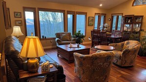 A cozy living room with a sofa, armchairs, a coffee table, and a dining area with chairs and a table.