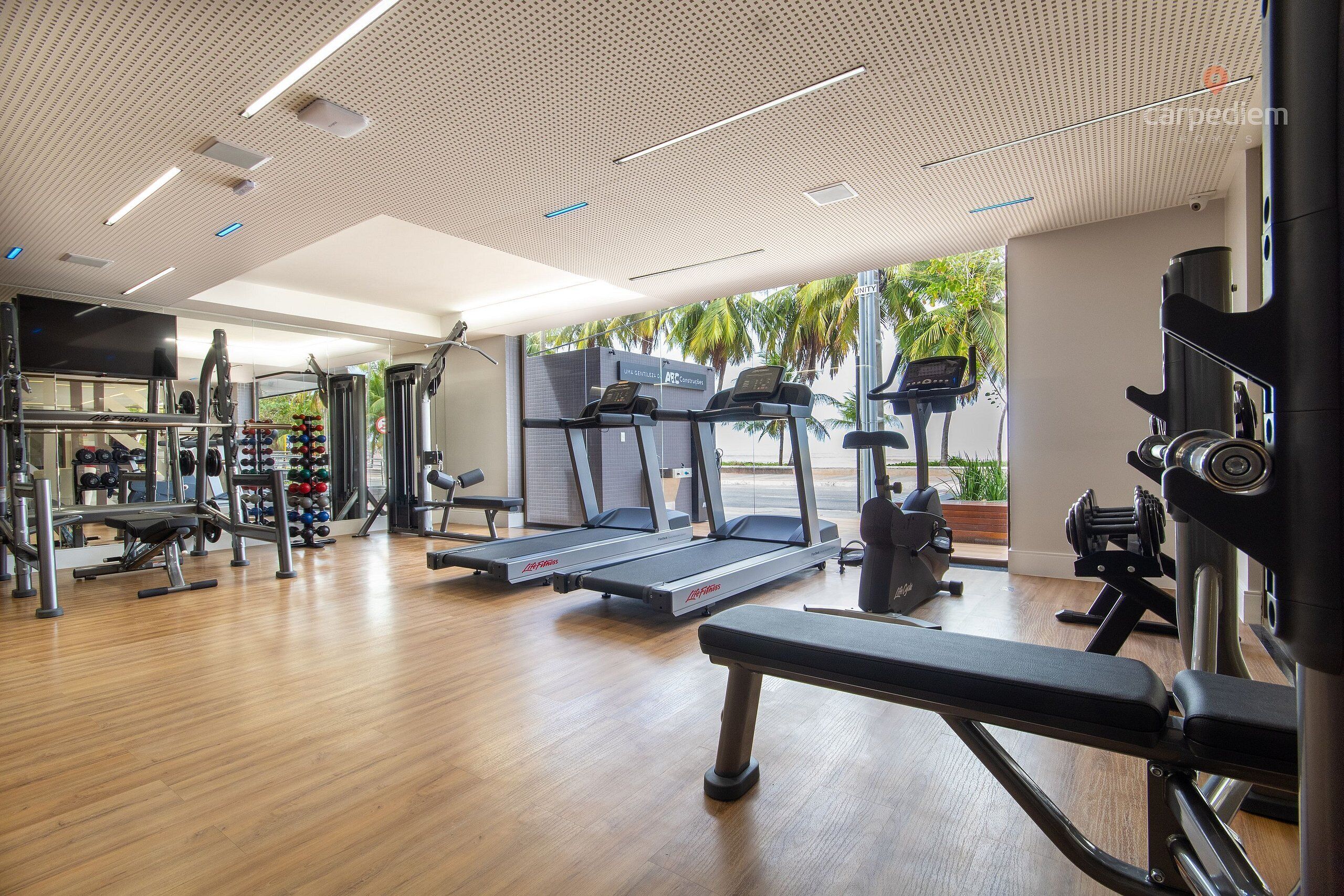 Una palestra con tapis roulant, macchinari per pesi e una panca.