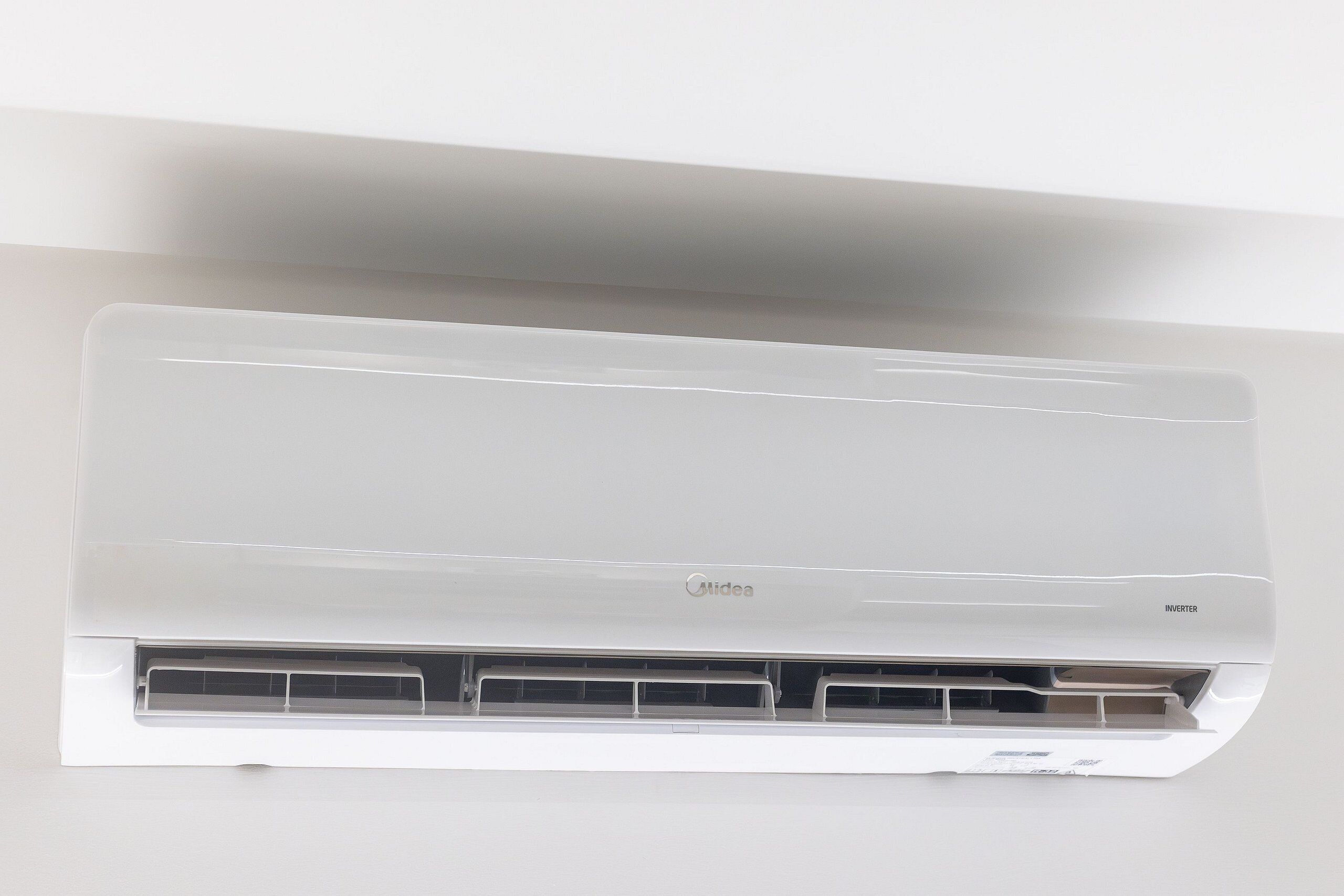 A white Midea inverter air conditioner mounted on a wall.