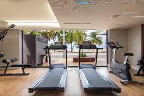 Ein Fitnessraum mit Laufbändern, einem Ergometer und einer Bank.