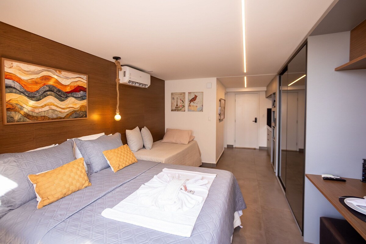 Ein modernes Hotelzimmer mit einem großen Bett, einem Schreibtisch und Blick auf den Flur.