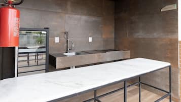 Una cocina moderna con encimera de mármol, un fregadero y un extintor.