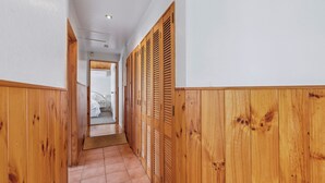 Un corridoio con rivestimenti in legno e pavimento piastrellato.