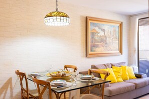 A dining area with a glass table, chairs, and a hanging light fixture. - Paraiso do Atlantico #102d - Style by Carpediem (Cabedelo)