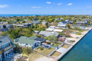 Un quartier résidentiel situé sur la côte, avec des maisons, un quai et une vue sur l’océan.
