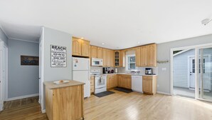 Une cuisine moderne avec des meubles de rangement en bois, un four à micro-ondes, une cuisinière et un petit plan de travail.