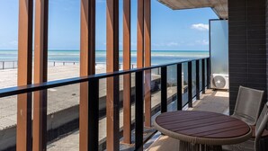 A balcony with a view of the beach, a round wooden table, and a black-framed window. - Alta Marine Housi Joao Pessoa by Carpediem (João Pessoa)