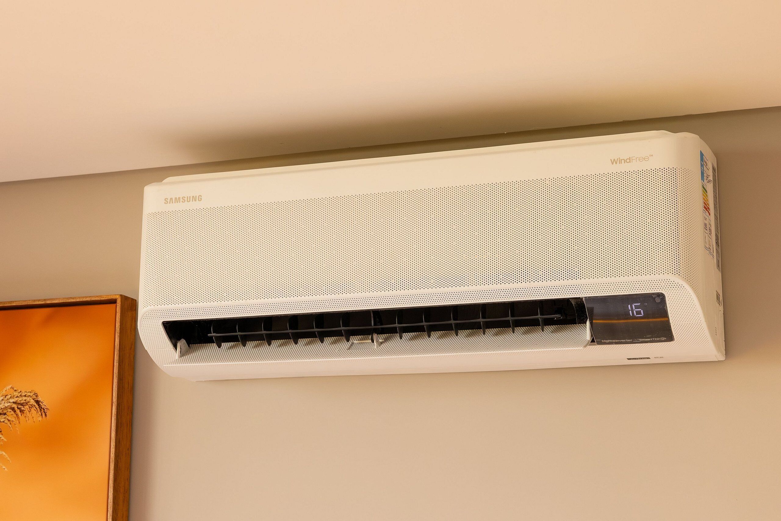 A white wall-mounted air conditioner with a digital display showing 16 degrees Celsius.