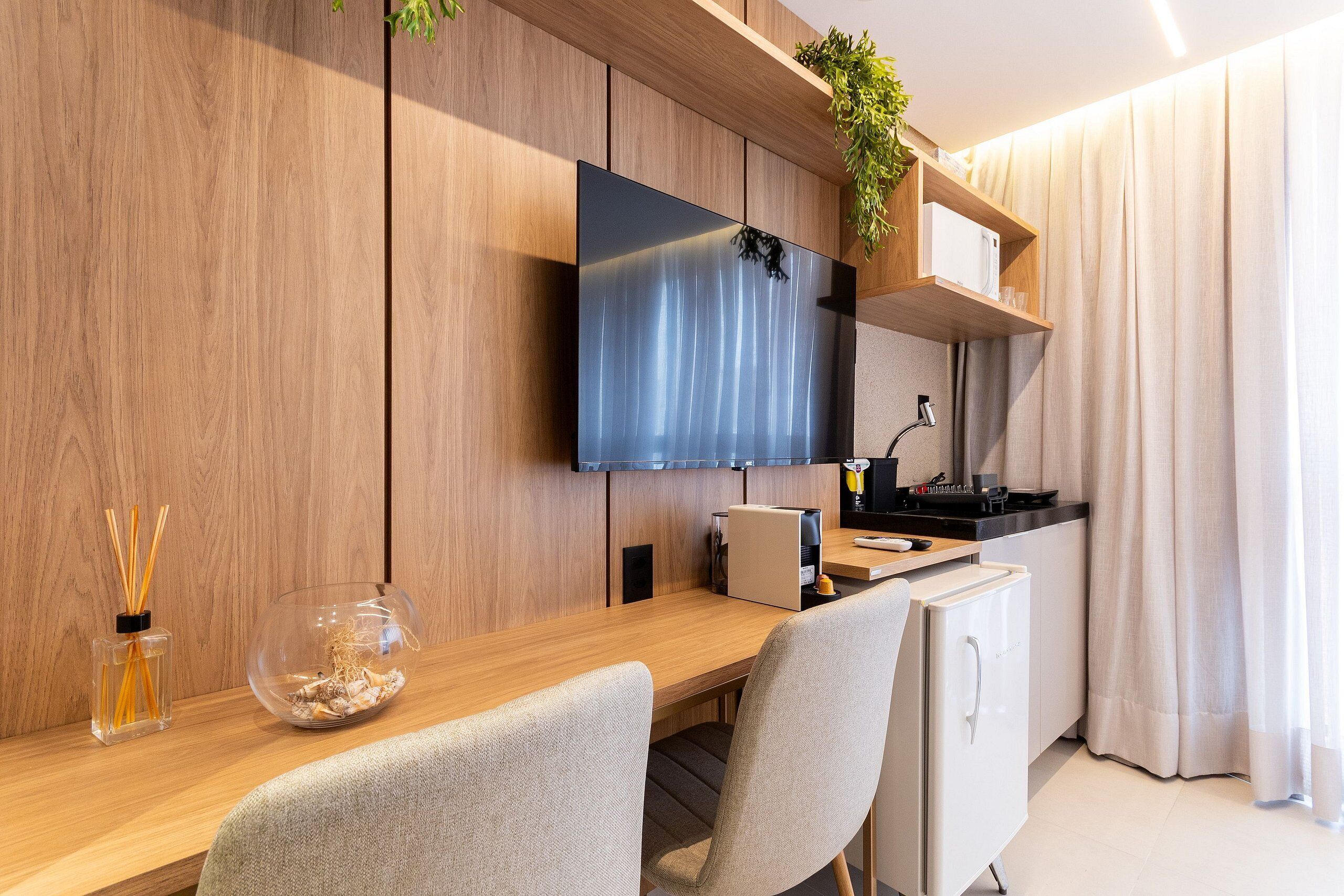 A modern kitchen with a wooden countertop, a built-in microwave, and a small refrigerator.