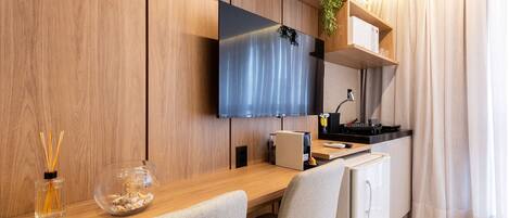 A modern kitchen with a wooden countertop, a built-in microwave, and a small refrigerator.
