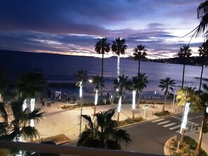 Blick auf einen Strand mit Palmen und einer Straße, die zum Strand führt.