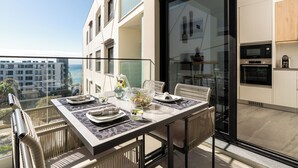 Un balcone moderno con un tavolo da pranzo per quattro, affaccio su una vista della città.