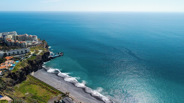 Un hotel sul lungomare con vista sulla spiaggia, una passeggiata e una scogliera che si affaccia sull'oceano.