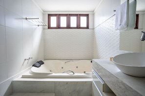 A modern bathroom with a freestanding bathtub, a large sink, and a window with wooden frames. - Garden House - Bessa Beach by Carpediem (João Pessoa)